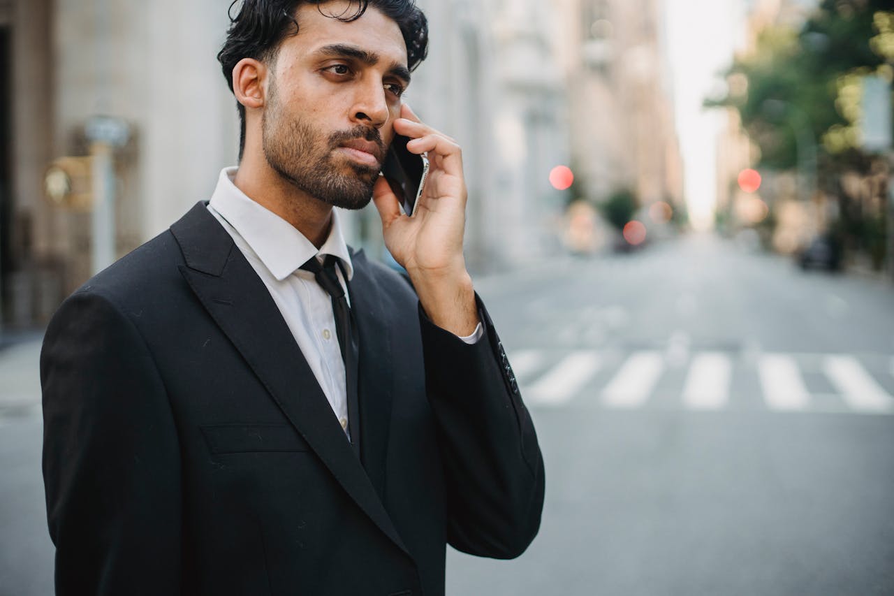 A professional businessman makes a phone call in the city, showcasing modern corporate life.